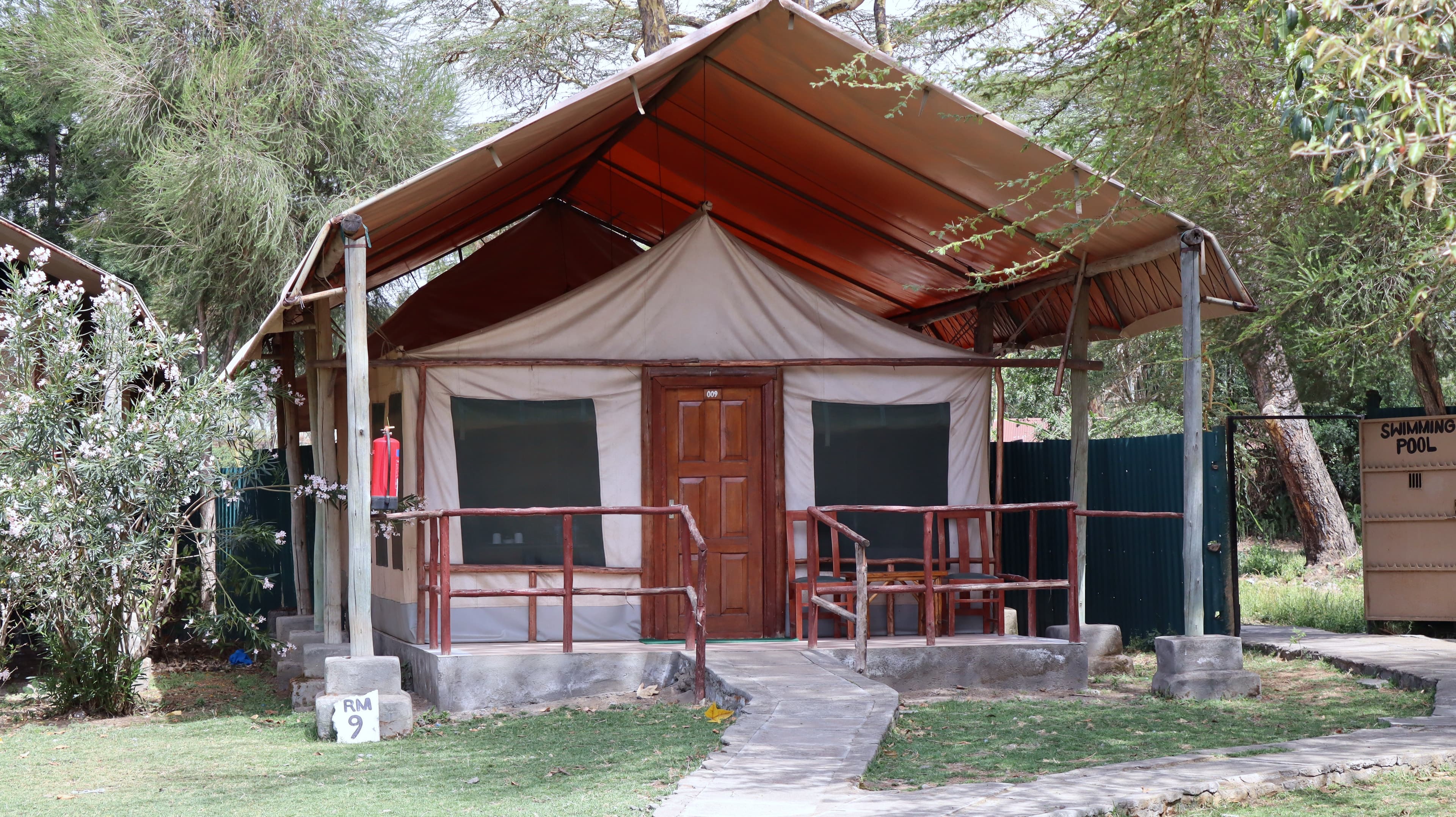 A canvas tent under a pitched canopy roof with a small verandah at Lake Naivasha Crescent Camp