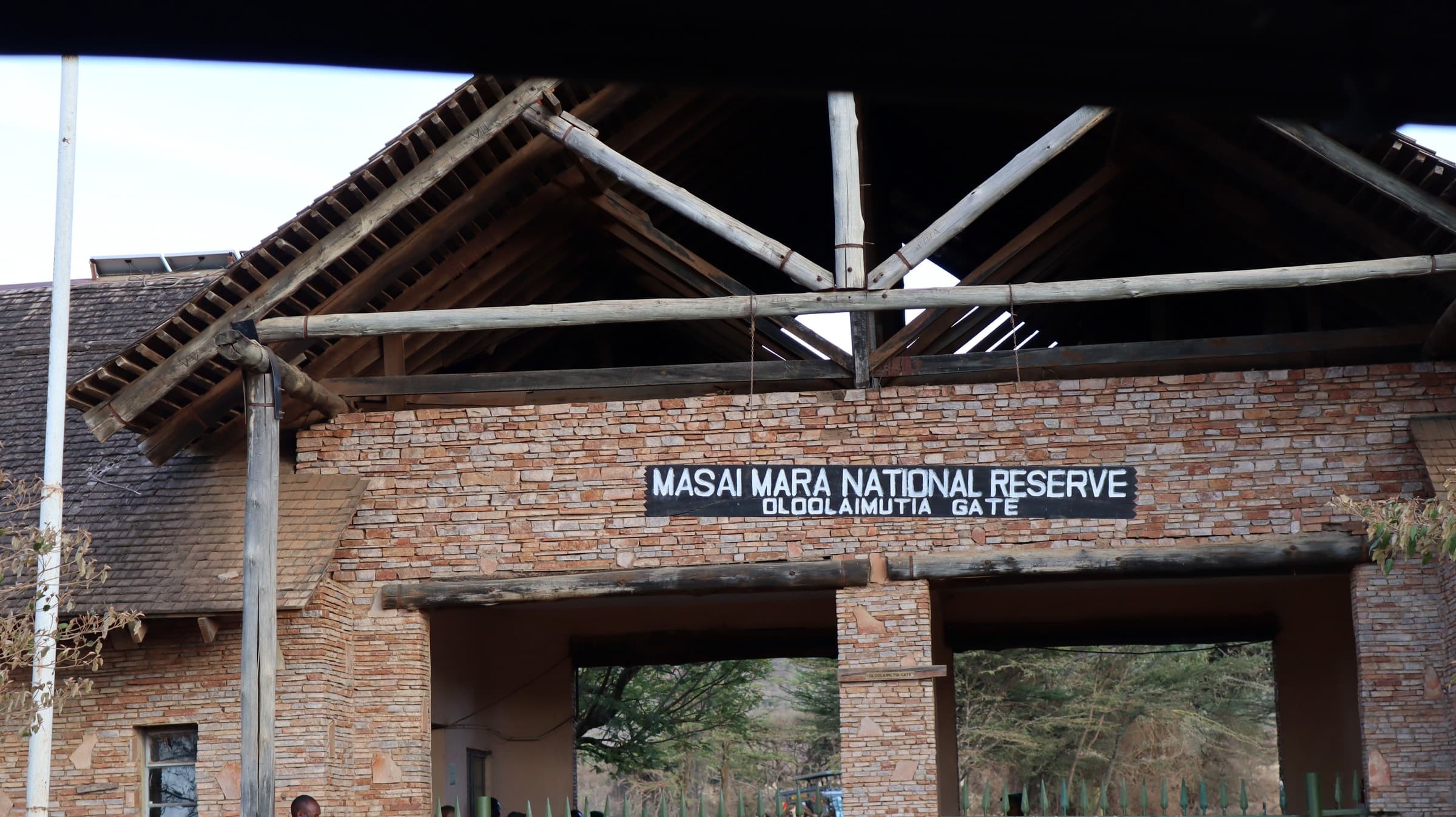 The Oloolaimutia Gate of the Masai Mara National Reserve, with the reserve's name on a sign above the entrance