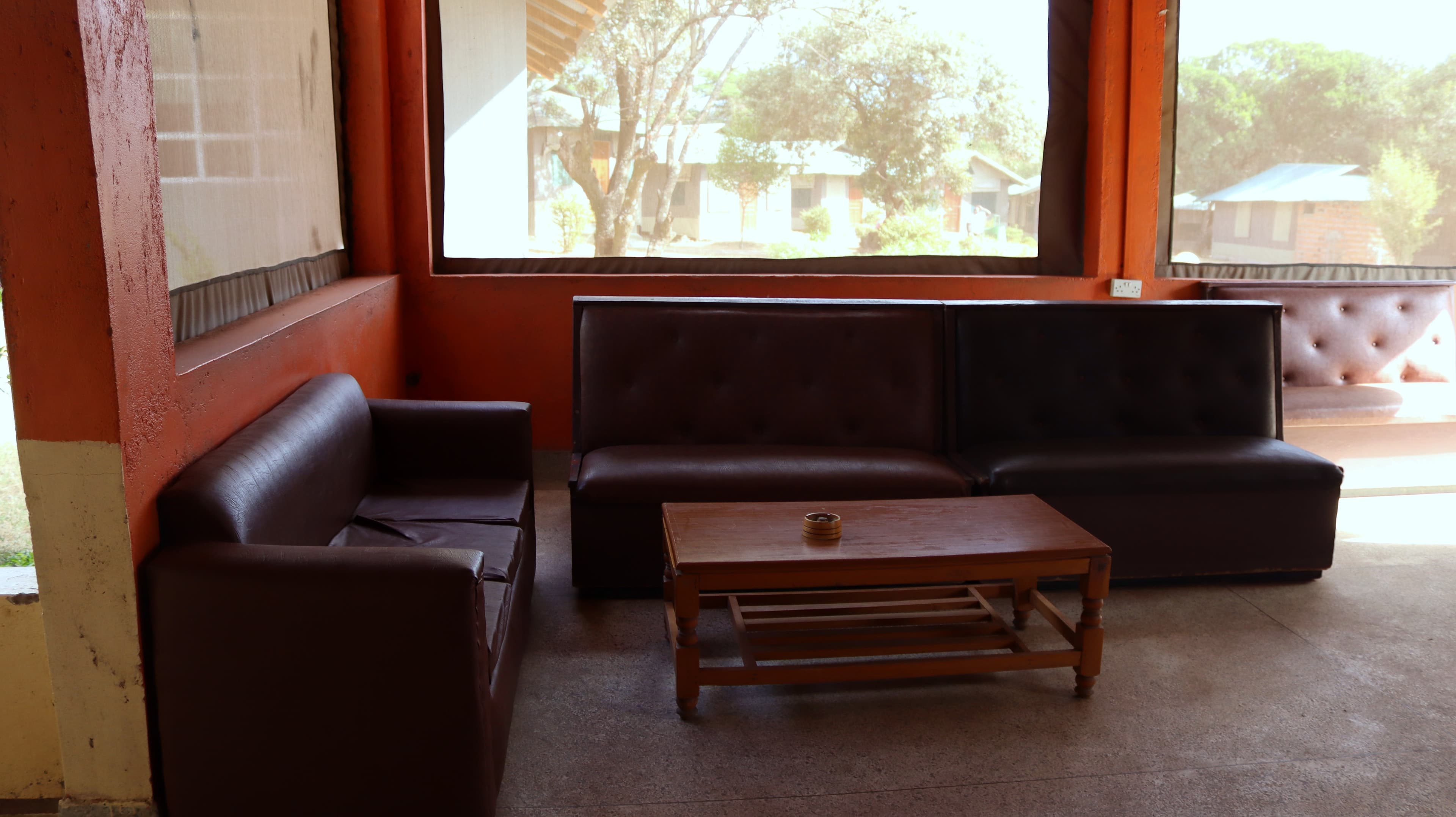 A lounge with leather sofas and a low table at Miti Mingi Eco Camp