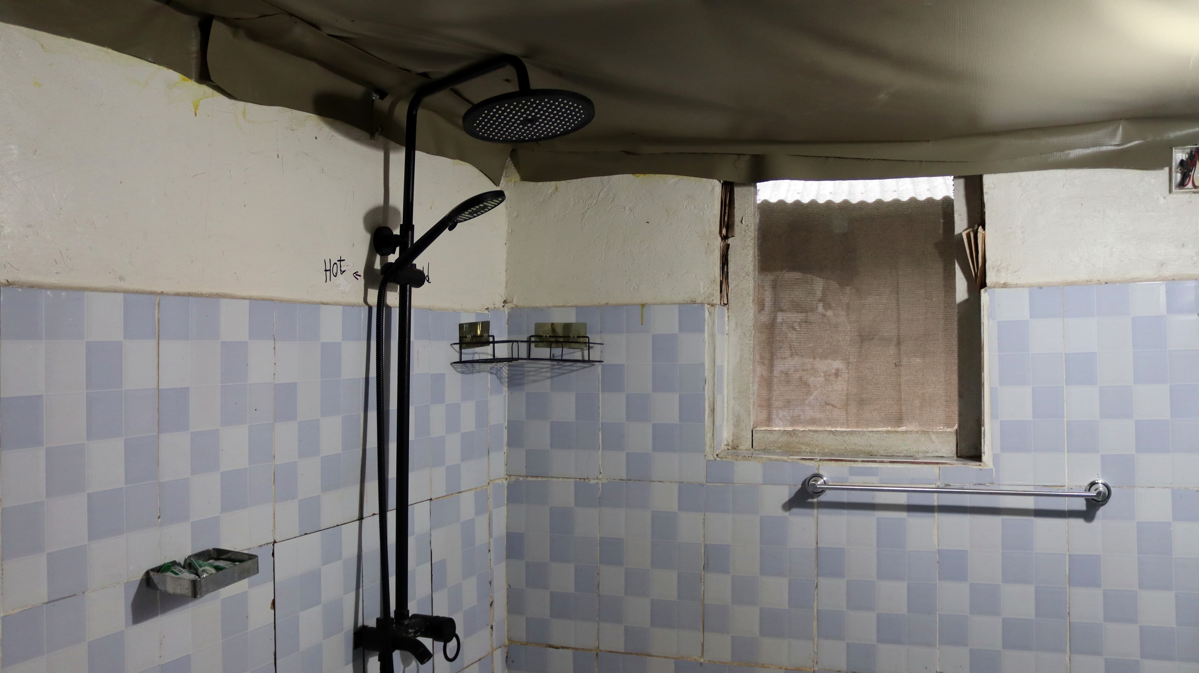 A tiled shower with a rain shower head in a guest tent bathroom at Miti Mingi Eco Camp