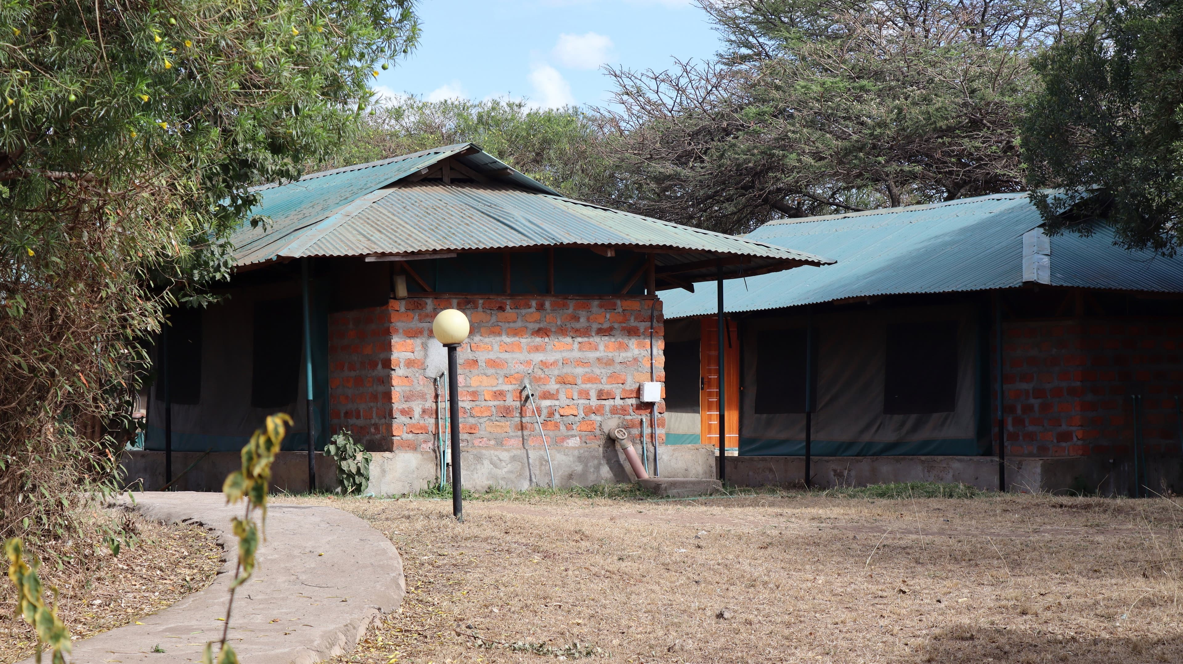 A path leading between buildings with green roofs at Miti Mingi Eco Camp
