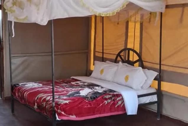 Bed and mosquito net inside a tent at Nyati Safari Camp